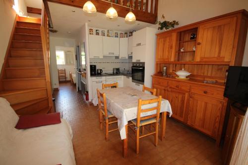 une cuisine avec une table et des chaises dans une pièce dans l'établissement Maison de vacances, MAS DE LA PLAGE, clim, terrasse Sud dégagée 4 couchages, 200m de la mer, PORTIRAGNES PLAGE LRMP67, à Portiragnes