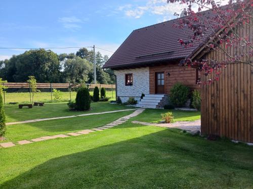 a house with a grass yard with a house at Chalupy v Podkrkonoší- Chalupa Oto, Chalupa Prade in Hostinné