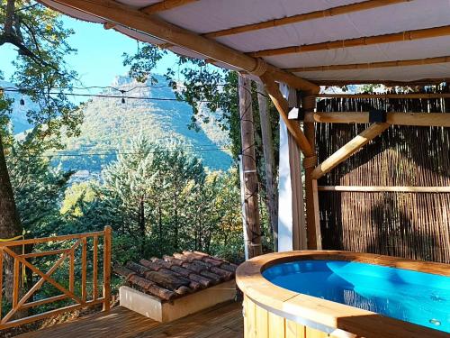 a hot tub on a deck with a view of a mountain at La Tiny du Midi in Tourrettes-sur-Loup