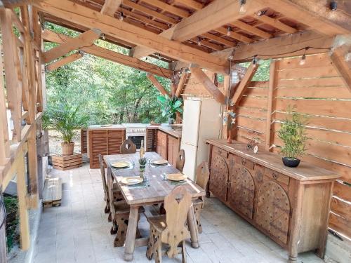an outdoor patio with a wooden table and a kitchen at La Tiny du Midi in Tourrettes-sur-Loup