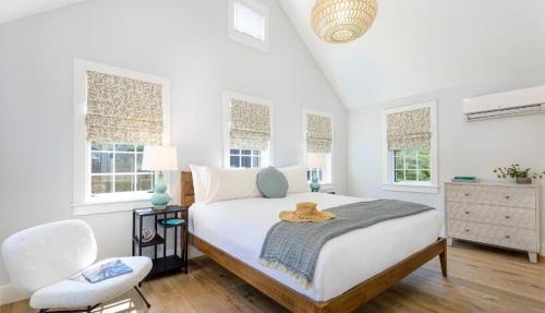 a bedroom with a bed and a chair and windows at Nantucket Resort Collection in Nantucket