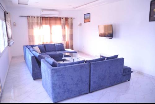 a living room with two blue couches and a table at RÉSIDENCE K&K - Lomé-Kégué-Kpatcha in Kopégan