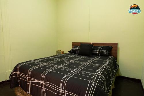 a bedroom with a bed with a black and white blanket at Viva Chile Santiago Centro in Santiago
