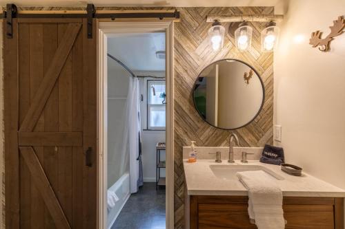 een badkamer met een schuurdeur en een wastafel met een spiegel bij Press Pause in Banner Elk