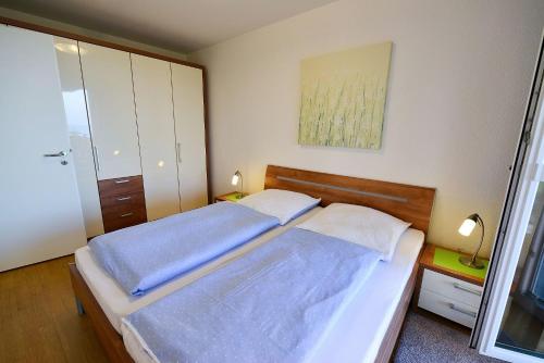 een slaapkamer met een bed met blauwe lakens bij Strandpalais PE08 in Cuxhaven