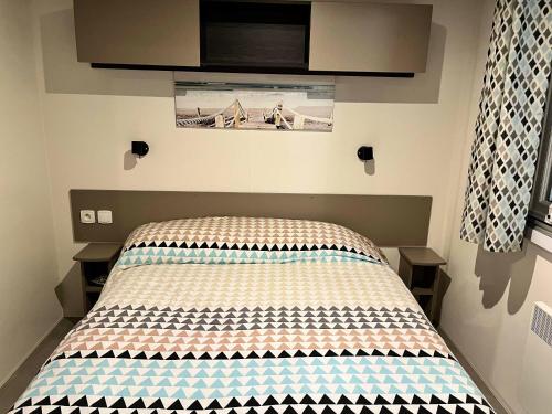 a bed in a small room with at Bungalow charmant au cœur de Les Mathes avec piscine partagée in Les Mathes