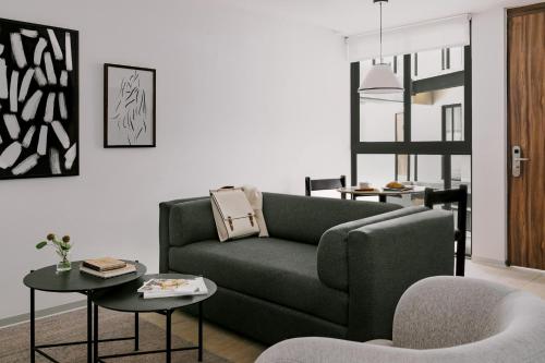 uma sala de estar com um sofá e uma mesa em Sonder Aria em Cidade do México