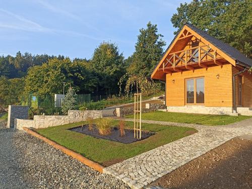 a log cabin with a garden in front of it at Domek w Górach Bardzkich in Kamieniec Ząbkowicki