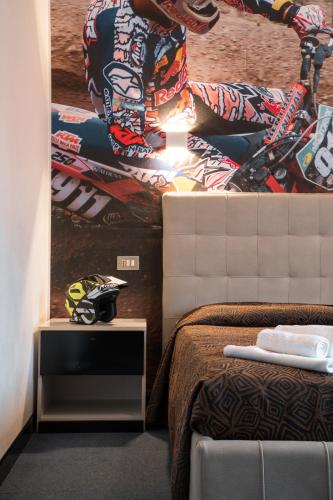 a bedroom with a picture of a motorcycle on the wall at Hotel Ciclamino in Pietramurata
