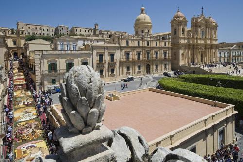 a large building with a statue in front of it at Villa Felicia in Noto