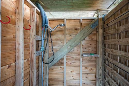 a shower in a wooden room with a wooden wall at Prime Time in Caswell Beach