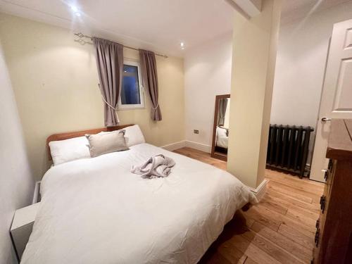Un dormitorio con una cama blanca con una toalla. en Spacious 2 bedroom apartment, en Londres