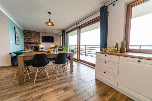 een keuken en eetkamer met een tafel en stoelen bij Willa Tałty in Mikołajki