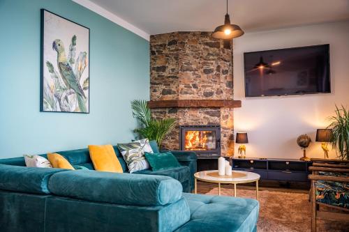 a living room with a blue couch and a fireplace at Willa Tałty in Mikołajki