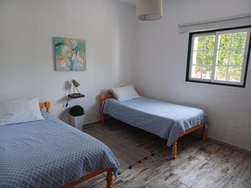 een slaapkamer met 2 bedden en een raam bij Quinta da Ponte das Hortas 3 in Elvas