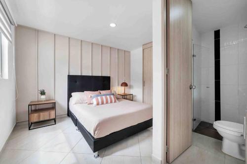 ein Schlafzimmer mit einem Bett und ein Badezimmer mit einem WC in der Unterkunft 3 bedroom apto in Sabaneta in Sabaneta