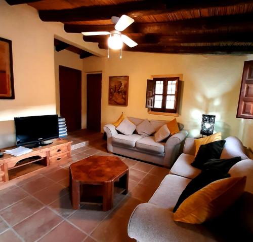 ビニュエラにあるLos Montes Traditional Casa with private poolのリビングルーム(ソファ、テレビ、テーブル付)