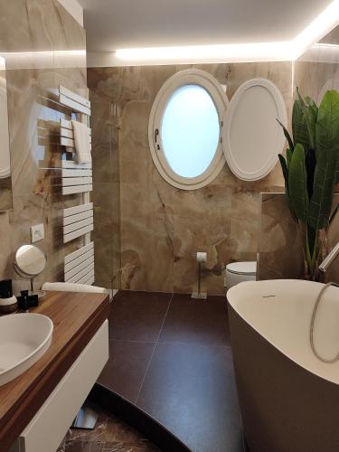 a bathroom with a tub and a sink and a window at Residenza Rialto in Bologna