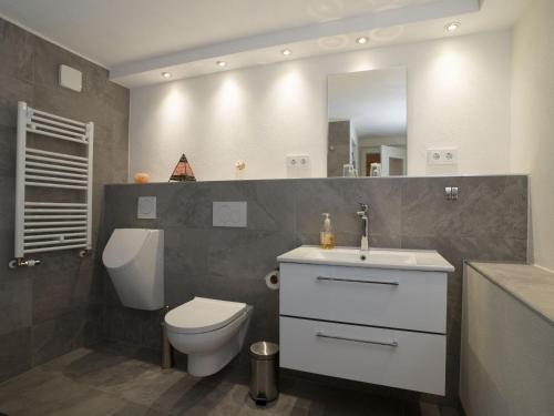 ein Badezimmer mit einem WC, einem Waschbecken und einem Spiegel in der Unterkunft Ferienwohnung Marianne und Heinz in Marpingen