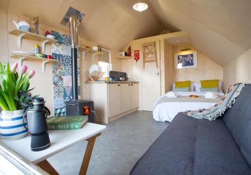 Habitación con cama y sofá en una habitación en St Aidan Beach Hut, en Alnmouth