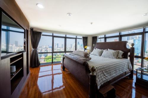 a bedroom with a bed and large windows at MN residence at Thonglor in Bangkok
