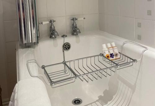 a bath tub with a towel rack on the side of it at Edgcott House in Exford