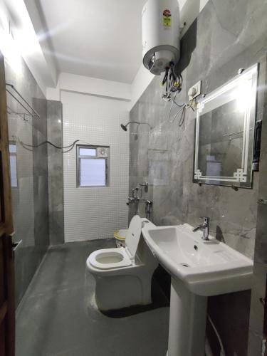 a bathroom with a white toilet and a sink at Jain Homestay in Darjeeling