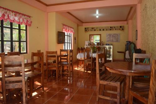 a restaurant with tables and chairs in a room at RnE Hometel Batanes in Ivana