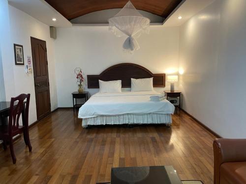 a bedroom with a large bed and a table at Nawaporn Place in Phuket