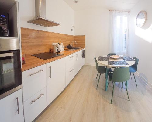 - une cuisine avec une table, une petite table et des chaises dans l'établissement Artbleu -Tout Confort - Idéal Pros - Proche commerces, à Montluçon