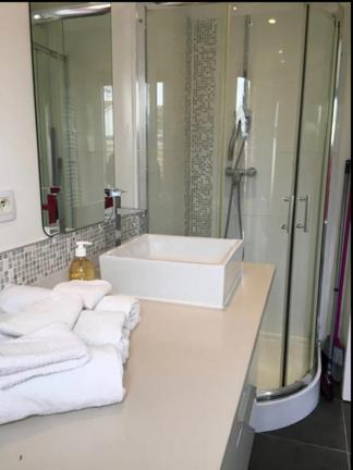 La salle de bains est pourvue d'un lavabo, d'une baignoire et de serviettes. dans l'établissement Petite maison avec jardin au coeur de Pornichet, à Pornichet