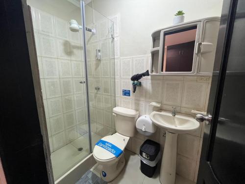 uma casa de banho com um chuveiro, um WC e um lavatório. em Suite Junior Urdesa Central. em Guayaquil