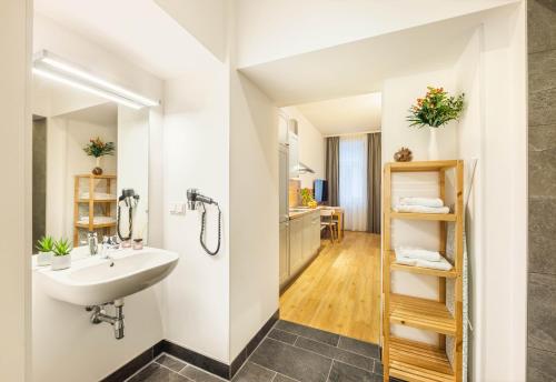 a bathroom with a sink and a toilet in a room at Jimmy's Apartments Emerald in Vienna