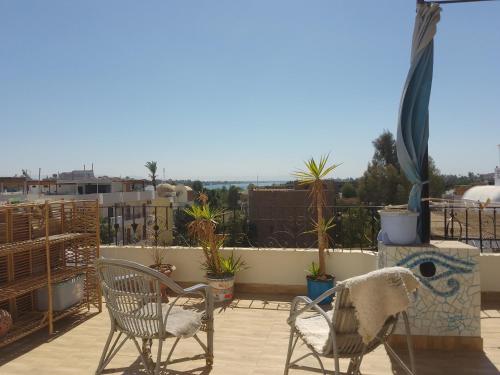 d'une terrasse avec 2 chaises et des plantes sur un balcon. dans l'établissement House of Dreams apartments Luxor, à Louxor