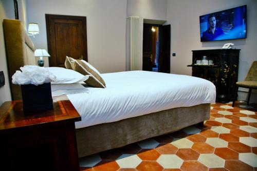 a bedroom with a large bed with a tv on the wall at Palazzo Papa Gregorio XVI in Tivoli