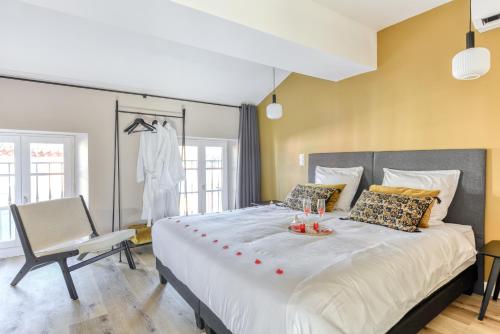 a bedroom with a large bed and a chair at Les Clés de Laure - Le 11 JACUZZI avec Terrasses Clim Netflix Parking in Carcassonne