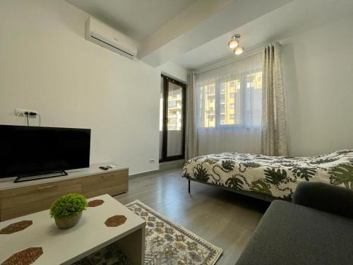 a living room with a bed and a flat screen tv at BELVEDERE Apartments in Bucharest