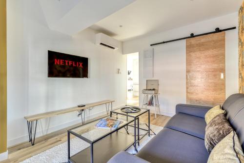 a living room with a couch and a table at Les Clés de Laure - Le 11 JACUZZI avec Terrasses Clim Netflix Parking in Carcassonne