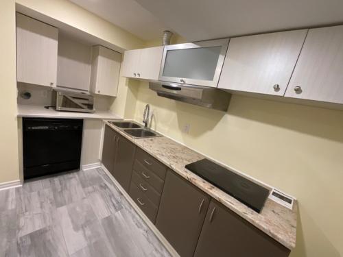 an empty kitchen with white cabinets and a sink at Beautiful Unit in Nepean Ottawa in Ottawa