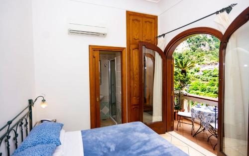 a bedroom with a bed and a balcony at Villa Palumbo in Positano