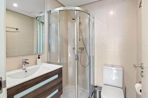 ein Bad mit einer Dusche, einem Waschbecken und einem WC in der Unterkunft Alcazaba Lagoon modern flat Ref M14 in Estepona