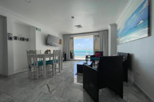 圣安德烈斯Apartamento con Vista al Mar en Sun Rise San Andrés的客厅配有桌椅,享有海景。