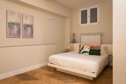 Un dormitorio con una cama blanca con almohadas. en Castore Apartment, en Milán