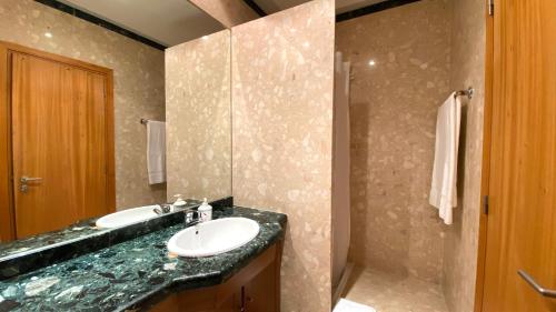 een badkamer met een wastafel en een douche bij Pleno Beach-side apartment Furadouro in Furadouro