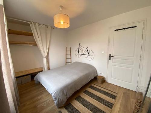 um quarto com uma cama e uma bicicleta pendurada na parede em Villa avec jacuzzi proche de la mer et du centre em Barbâtre