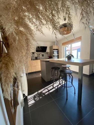 une cuisine avec une table et deux tabourets dans l'établissement Villa avec jacuzzi proche de la mer et du centre, à Barbâtre