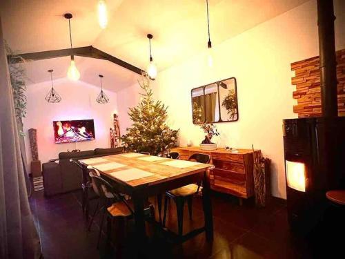 uma sala de jantar com uma mesa e uma árvore de Natal em Villa avec jacuzzi proche de la mer et du centre em Barbâtre