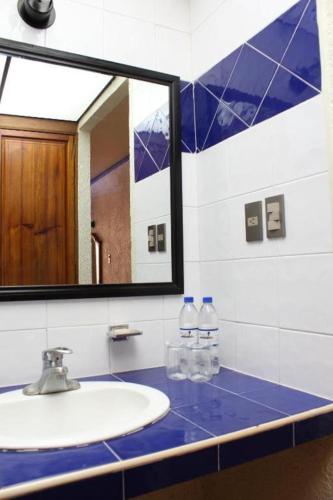 a bathroom with a sink and a mirror at Hotel Oaxaca Dorado in Oaxaca City