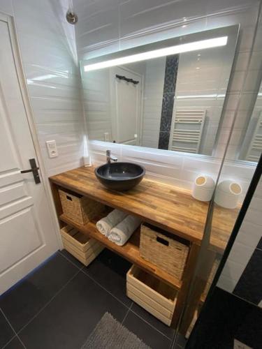 une salle de bain avec un lavabo et un miroir dans l'établissement Villa avec jacuzzi proche de la mer et du centre, à Barbâtre