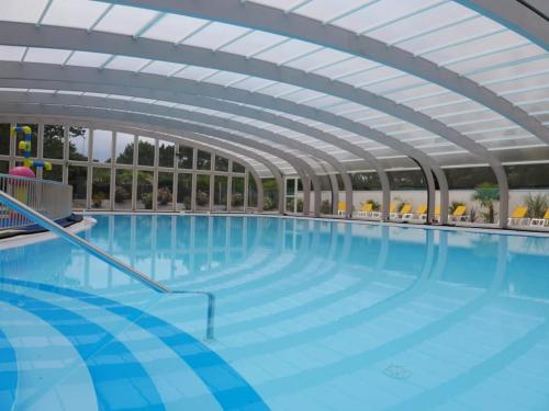 a large indoor swimming pool with a ceiling at Camping Officiel Siblu Le Bois Dormant in Saint-Jean-de-Monts